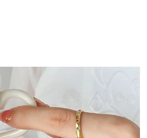 Détail d'une bague plaquée or 18 carats avec trois petits oxydes de zirconium colorés
