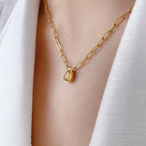Macro detail of teardrop yellow zircon pendant on 18K gold-plated titanium steel chain