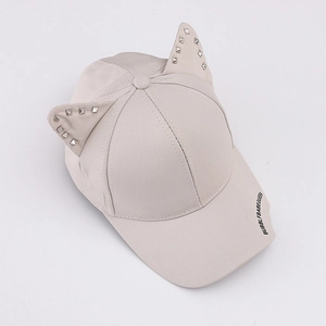 Detalle de la gorra de béisbol de algodón beige con orejas de gato y tachuelas plata