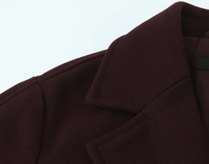 Detail view showing stitching and texture on burgundy wool blend coat collar and shoulder