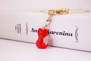 Detail view of a red fox keychain with crystal accents resting on an open book