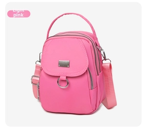 Detailed view of light pink nylon mini bag with adjustable straps and silver hardware