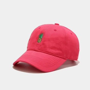 Close-up of pink baseball cap featuring detailed pineapple embroidery and cotton canvas texture