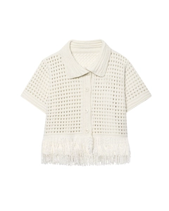 Dettaglio del cardigan in maglia crema con motivi all'uncinetto e lunghe frange