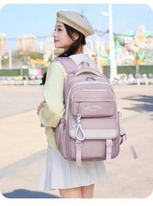 Detail of light purple nylon backpack with star charm and printed text on outdoor model