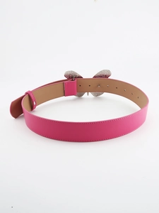 Detail of pink faux leather belt featuring a large silver metal butterfly buckle design