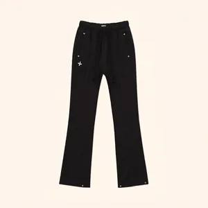 Detail of black flared joggers featuring a drawstring waist and silver stud accents