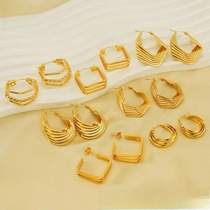 Flat lay of diverse 18K gold irregular lava earrings on a textured display board