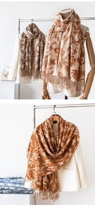 Detail of floral cashmere-style scarves in beige and brown with elegant fringe accents
