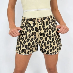 Détail de short en jean taille haute à imprimé léopard avec bords effilochés et bouton