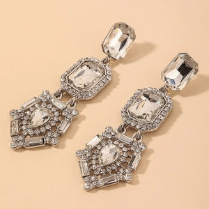 Detailed view of luxury geometric silver drop earrings with faceted clear crystals