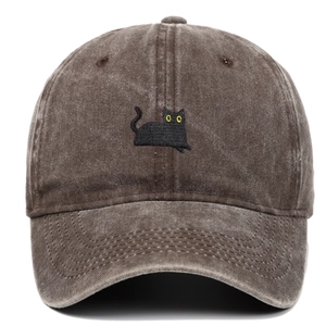 Nahaufnahme von gewaschenem Baumwollstoff und schwarzer Katzenstickerei auf der Kappe