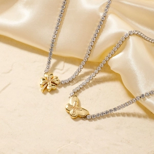 Golden clover and butterfly necklaces with zircon tennis chains on champagne silk backdrop