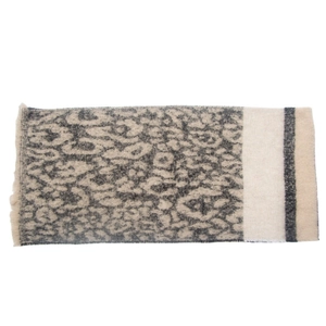 Close-up of leopard print scarf with fringe tassels and beige striped patchwork detail