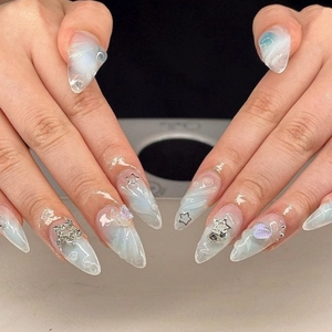 3D almond press-on nails with blue marble texture, lavender hearts, and silver stars