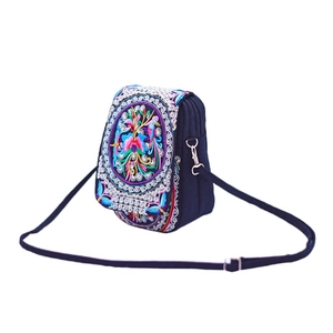 Detailed embroidery of colorful flowers and birds on dark blue ethnic crossbody canvas bag