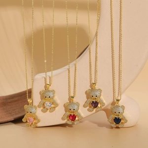 Detailed view of bear pendant with heart-shaped zircon and full pavé stones on gold chain