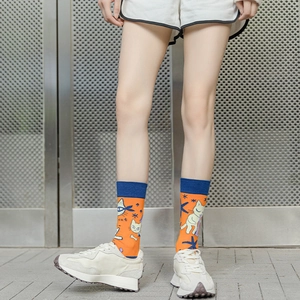 Detailed view of orange cotton socks with cartoon cat patterns and star motifs