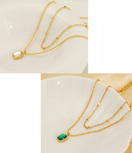 Detail of emerald and white zircon pendants on gold-plated stainless steel necklaces