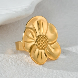 Macro shot of 3D floral ring detail featuring textured petals and a matte gold finish