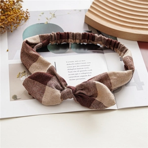 Detail of plaid bunny ear headband featuring brown checkered fabric and elastic band