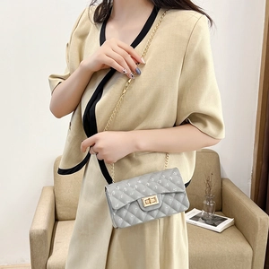Elegant grey quilted jelly shoulder bag with gold chain strap shown on a female model