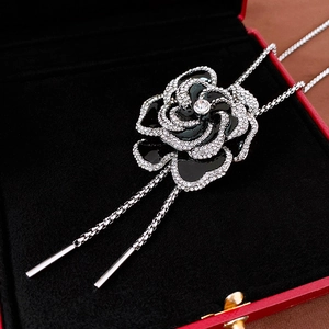 Macro shot of black enamel camellia earring with crystal pavé and silver chain detail