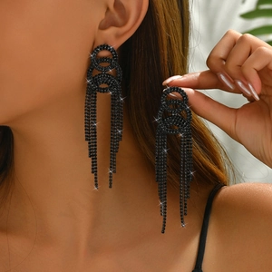 Macro shot of black tassel earrings with sparkling rhinestones and metal ring details