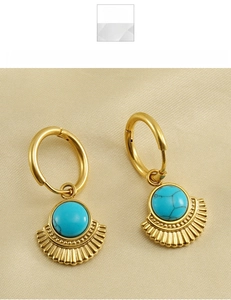 Close-up of vintage fan-shaped turquoise earrings in gold titanium steel on silk