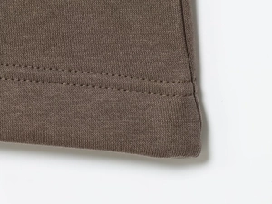 Detailed macro view of the brown knitted loungewear set featuring double-needle hem stitching
