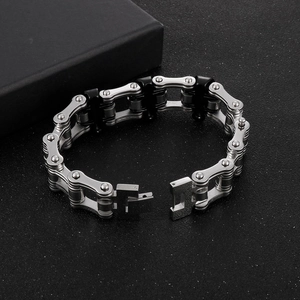 Detail of silver and black motorcycle chain bracelet with industrial buckle on black box