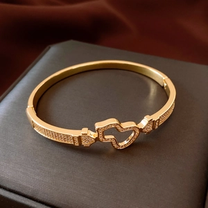 Detail of 18K gold-plated bangle with hollow heart design and pavé cubic zirconia