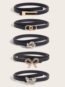 Close-up of five black fashion belts with diverse gold and silver metal buckles