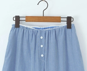 Details von blau gestreiften Shorts mit weißem Spitzenbesatz und Zierknöpfen am Bund