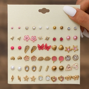 Detailed close-up of 30 pairs of assorted stud earrings on a display card for women