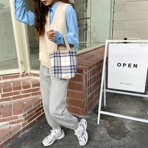 Plaid canvas tote bag styled with a beige knit vest and casual street outfit