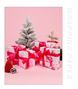 Pink Christmas wrapping paper with cartoon reindeer pattern and holiday gift decorations