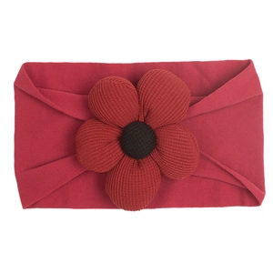 Detail of soft nylon dark red baby headband with a 3D textured floral fabric ornament
