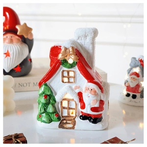 Close-up of ceramic Christmas snow house decoration with LED warm light and Santa Claus
