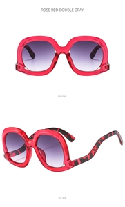 Detail view of large irregular rose red sunglasses with gradient lenses and leopard temples