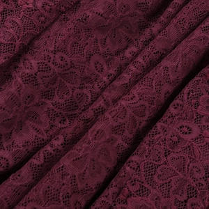 Detailed close-up of wine red lace fabric with floral embroidery and elegant textures