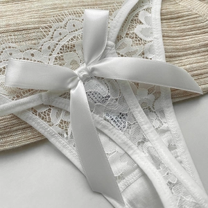 Sexy white floral lace thong with a large satin bow accent and sheer mesh texture