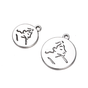 Macro view of vintage silver coin pendants featuring artistic profile engravings for jewelry