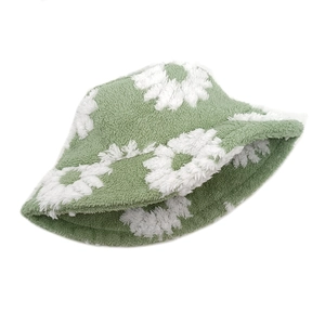 Detailed close-up of green plush bucket hat with white sunflower patterns and soft texture