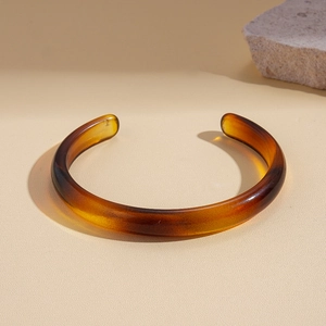 Detail view of amber tortoise shell acrylic C-shape cuff bracelet with natural stone