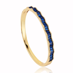 Modern 18k gold plated wave bangle featuring rectangular blue crystal stones