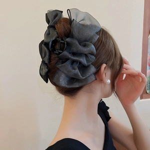 Vue détaillée de la grande pince à cheveux noeud en organza gris avec paillettes argentées