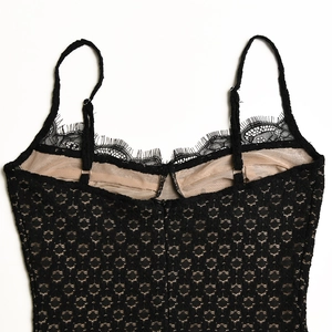 Dettaglio del pizzo floreale nero con spalline regolabili e fodera beige morbida