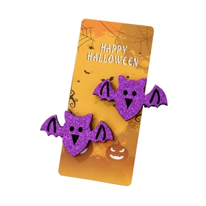 Pair of purple glitter bat hair clips for Halloween party on a themed card display