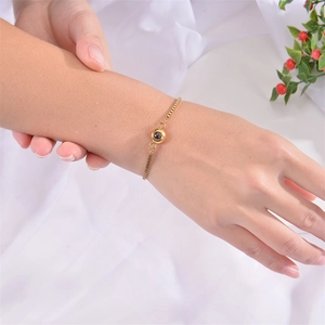 Dettaglio di un bracciale a proiezione in acciaio dorato al polso con decoro elegante